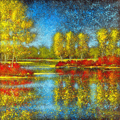 Gold and red trees reflect at the waters edge