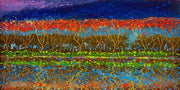 Mirror image on the waterfront of groves of trees in red and blue sky